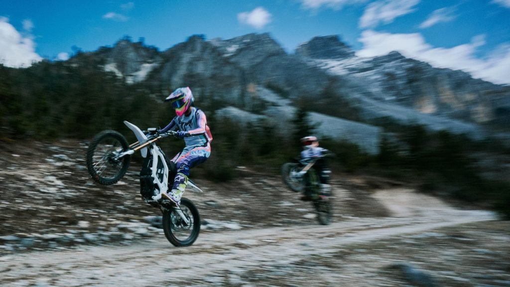 Rider wheelieing a Light Bee 2 X on a dirt trail